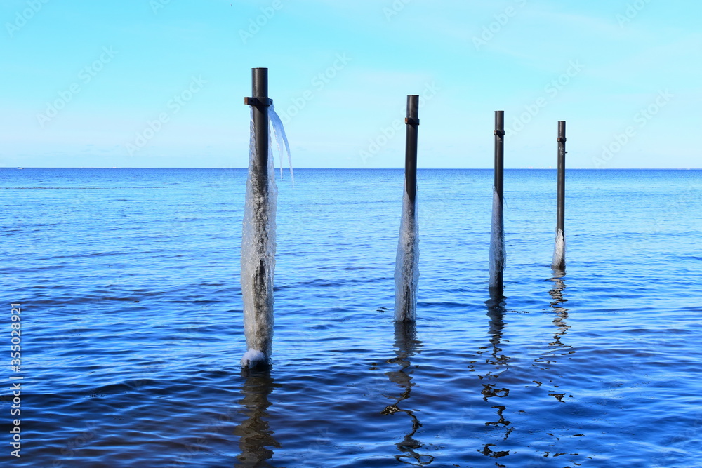 Metal poles in the sea near the shore.