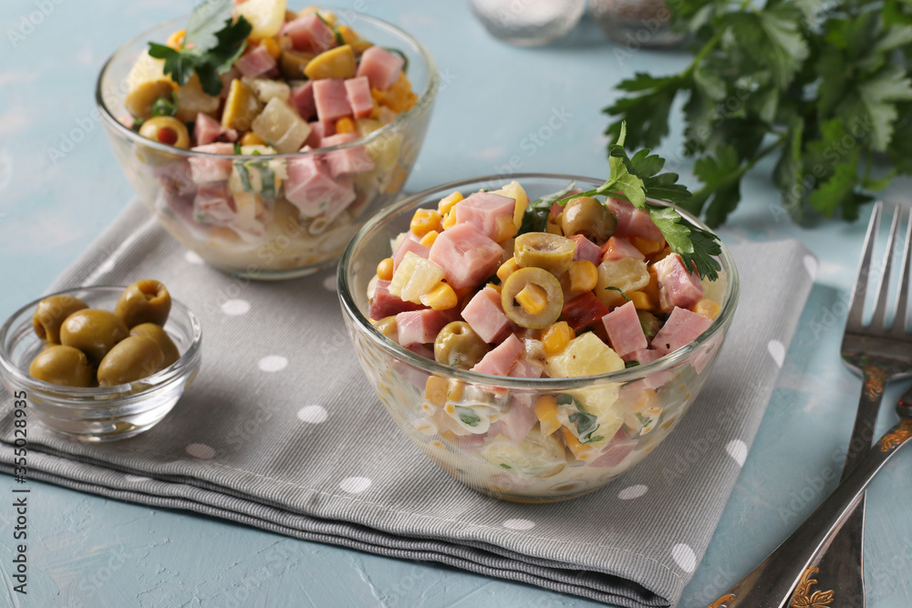 Salad with ham, olives, corn and pineapples in transparent salad bowls on a light blue background, Horizontal format Salad with ham, olives, corn and pineapples in transparent salad bowls on a light blue background, Horizontal format