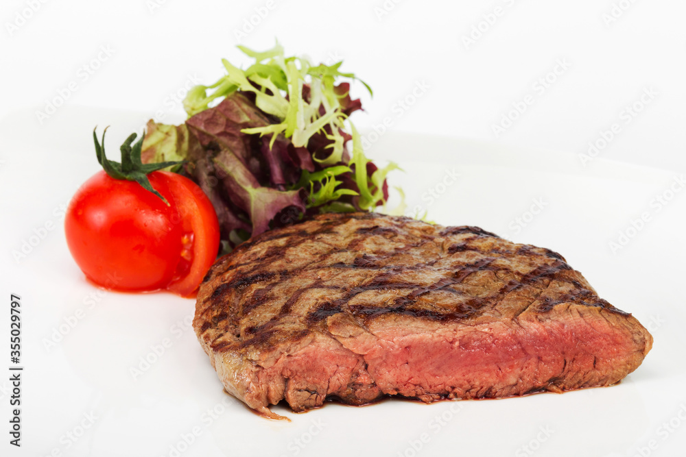 Steak with blood of beef with tomatoes, herbs and lettuce, selective focus. For design of menus, cookbooks, advertising products for the restaurant business Steak with blood of beef with tomatoes, herbs and lettuce, selective focus. For design of menus, cookbooks, advertising products for the restaurant business