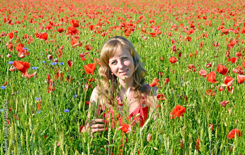 Portrait of a young woman among red poppy © vodolej
