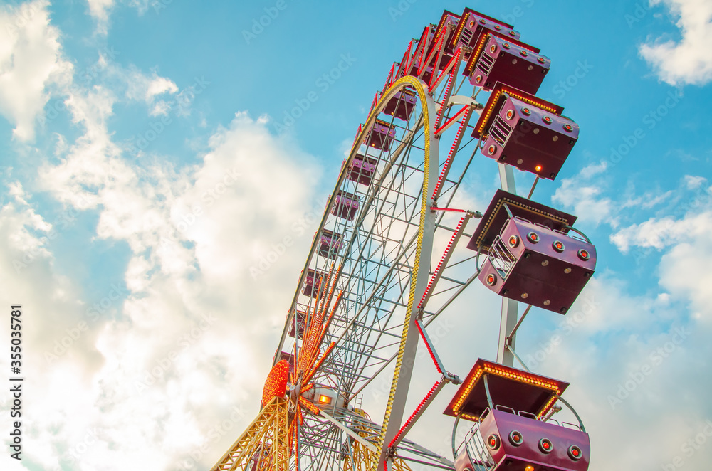 Ferris wheel on a blue sky with clouds - obrazy, fototapety, plakaty 
