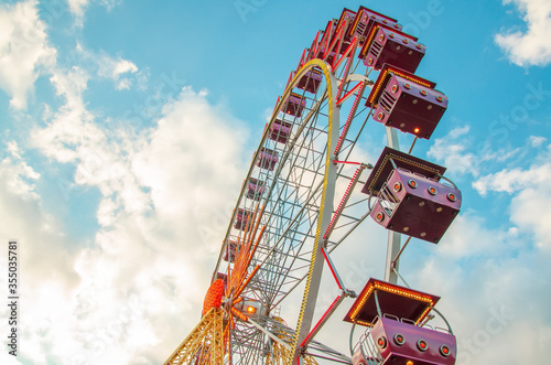 Ferris wheel on a blue sky with clouds photo