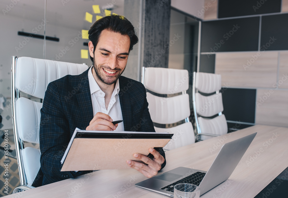 Businessman sitting in his office, writting on papers, with copy space. Businessman sitting in his office, writting on papers, with copy space.