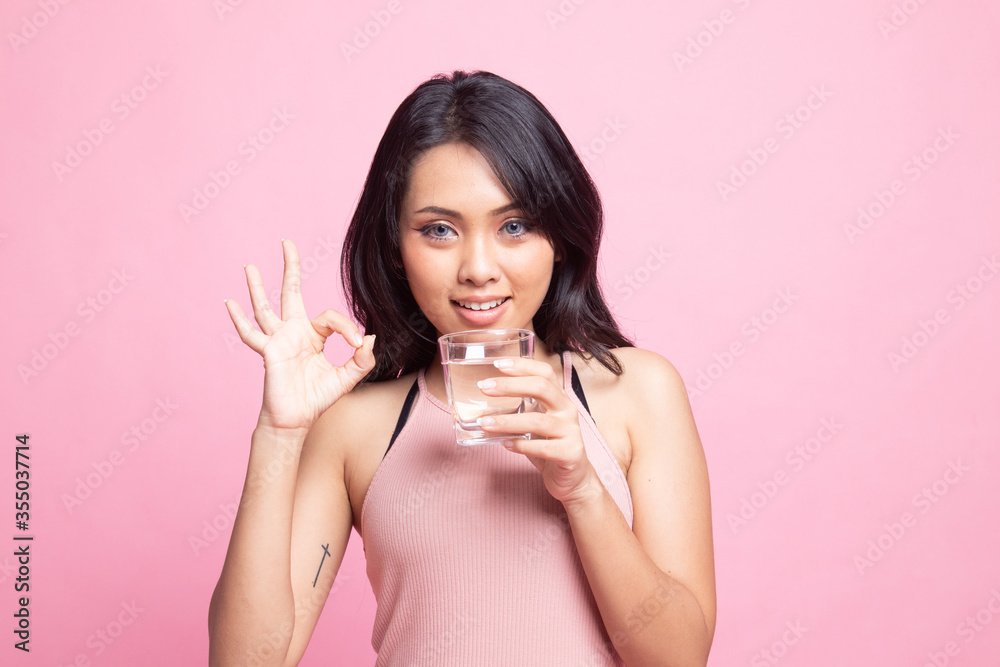 Young Asian woman show OK with a glass of drinking water. Young Asian woman show OK with a glass of drinking water.