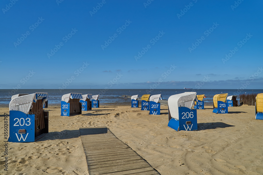 beach chairs on empty beach in Cuxhaven-Döse (Germany) during Corona (Covid 19) lock down in April 2020 on a bright sunny day with blue sky
