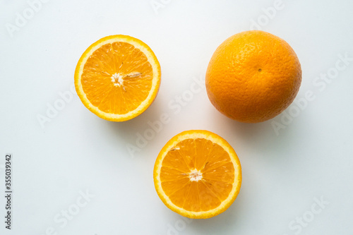 group of orange fruits isolated on a white table. cut orange. view from above