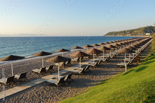 Sun beds and umbrellas on the sea coast.            © SERGEY