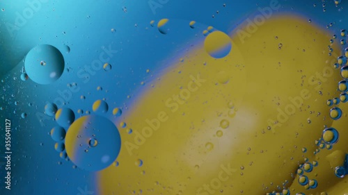 High quality abstract close-up 4k slow motion video of a bright colourful natural bacground with lemons and oranges giving orange blue and yellow colours with the water and oil bubbles moving around