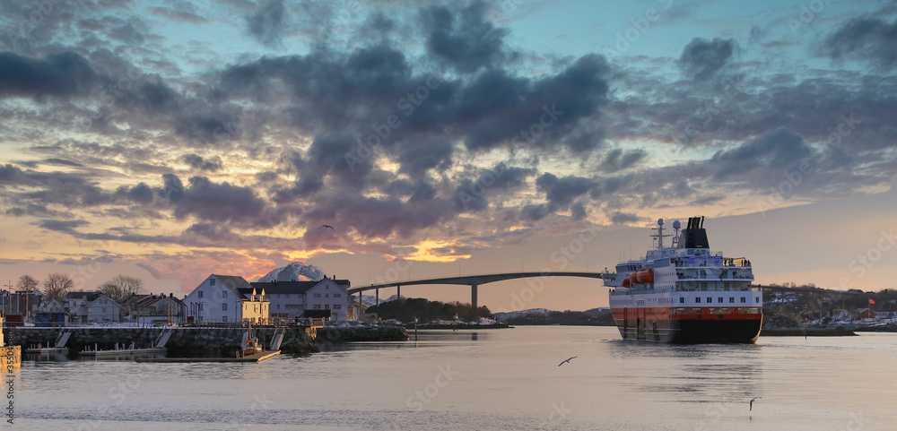 Coastal ships depart from Bronnoysund harbor in sunset, Northern Norway