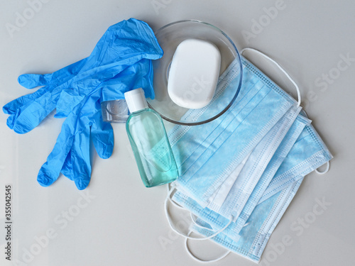 Covid-19 prevention concept background, rubber gloves, hand sanitizer, surgical masks and antibacterial soap isolated on white background, medical backdrop