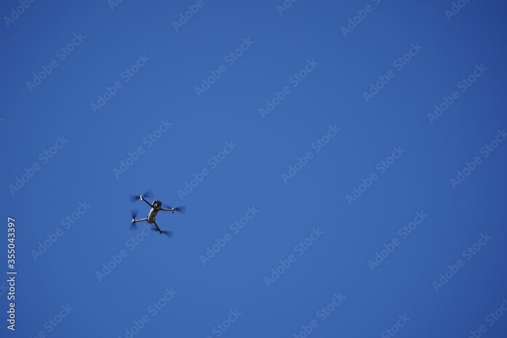 Unmanned drone flying in the air, blue background. Unmanned drone flying in the air, blue background.