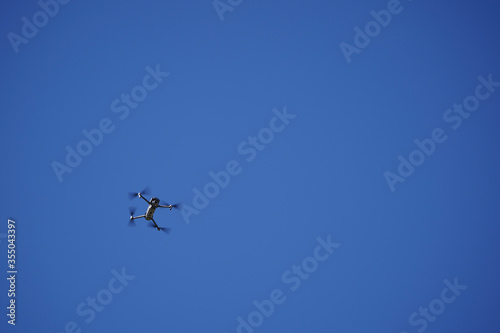 Unmanned drone flying in the air, blue background.