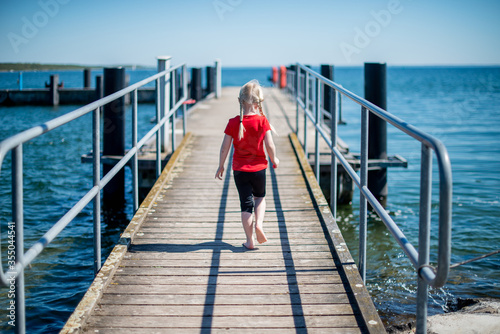 Girl walking on bridge. Reuniting with nature. Childhood, lifestyle. 