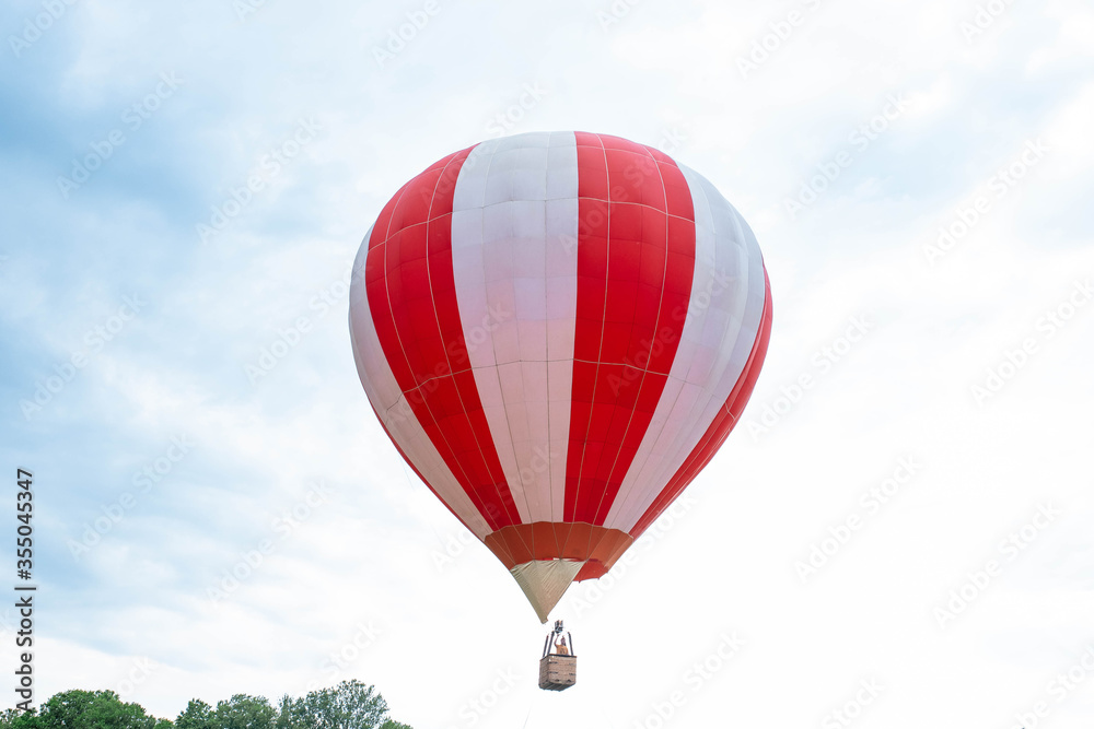 Fototapeta premium Balloon in the blue sky. Red balloon in the blue cloudy sky.