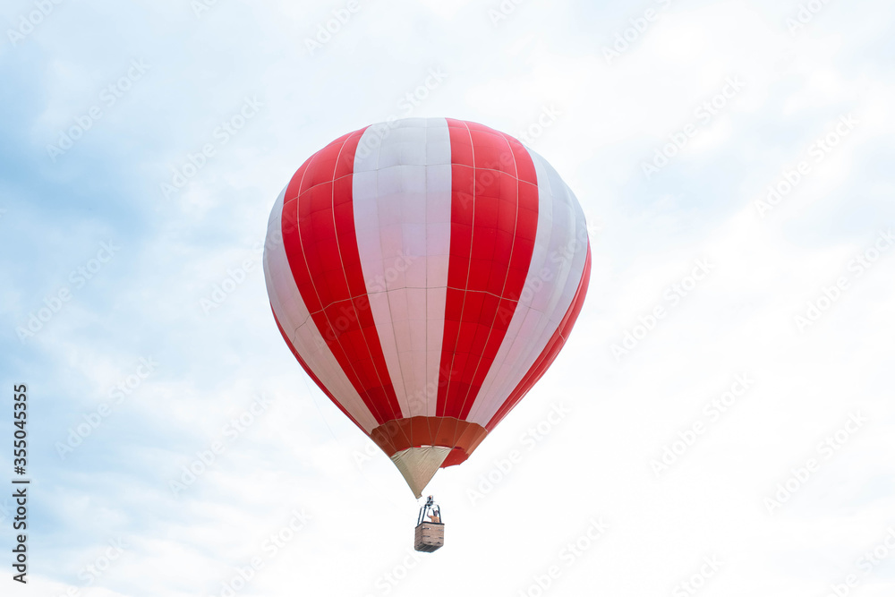 Fototapeta premium Balloon in the blue sky. Red balloon in the blue cloudy sky.