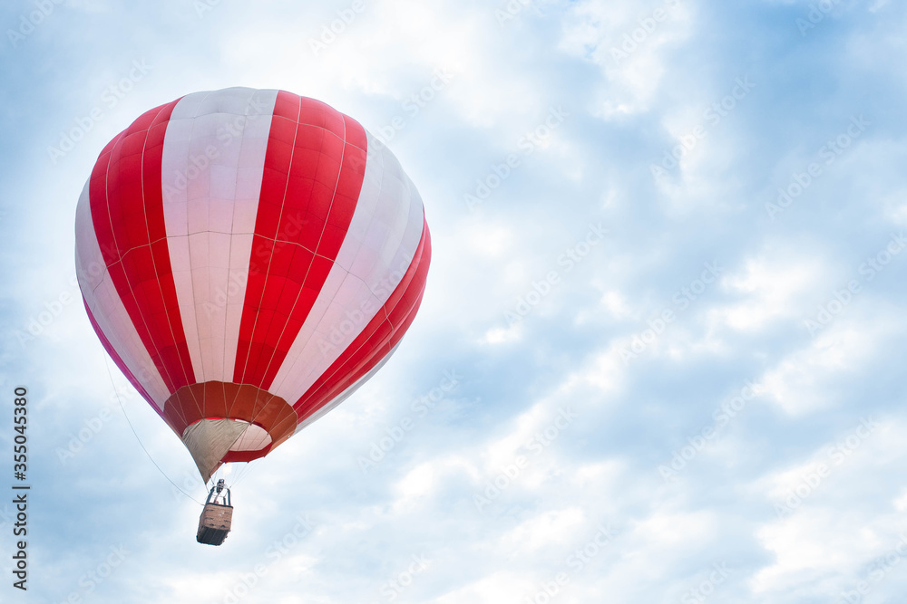Fototapeta premium Balloon in the blue sky. Red balloon in the blue cloudy sky.