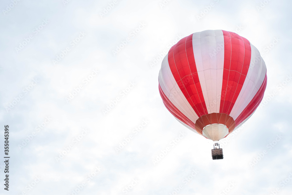 Fototapeta premium Balloon in the blue sky. Red balloon in the blue cloudy sky.
