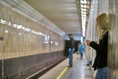 Russia Moscow June 2020. Moscow metro. a girl in a protective mask rides waiting for a metro train on the platform. coronavirus epidemic in Russia. viral risk of infection. © LemPro Filming Life