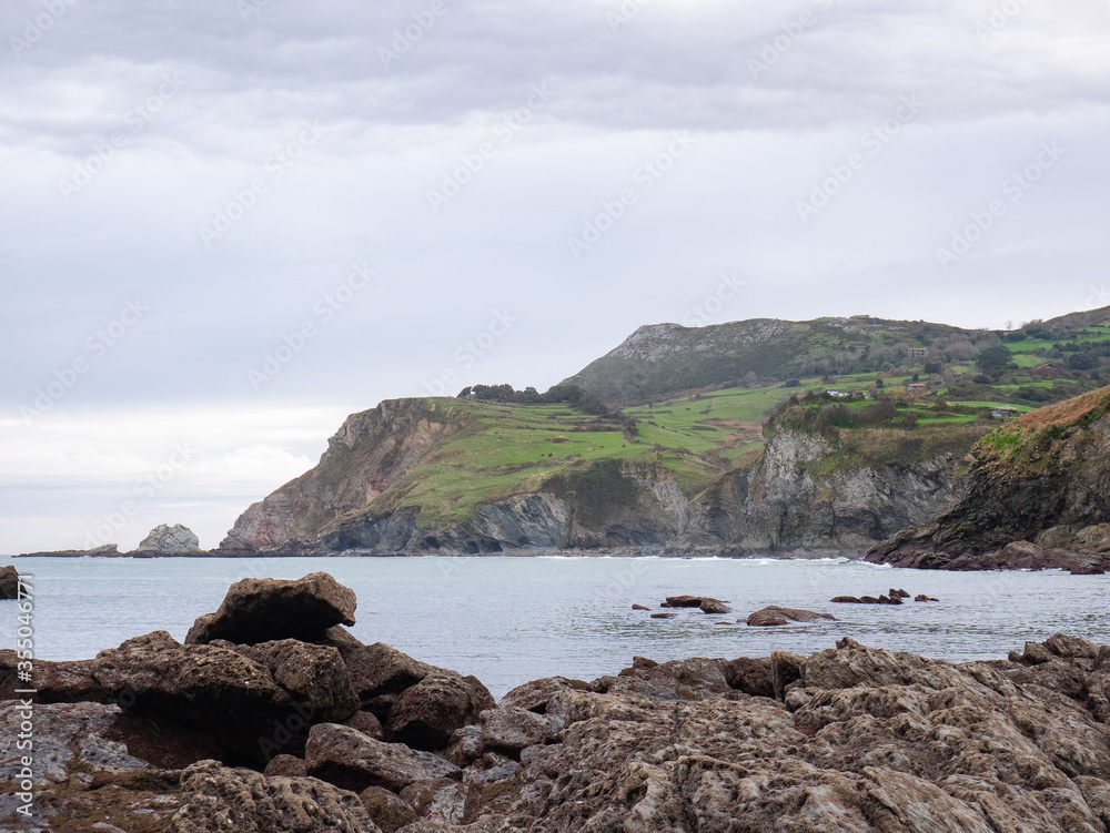 View of the coast, the Cantabrian Sea and the `La Soledad` beach from `El Tunel` in Laredo on a cloudy day