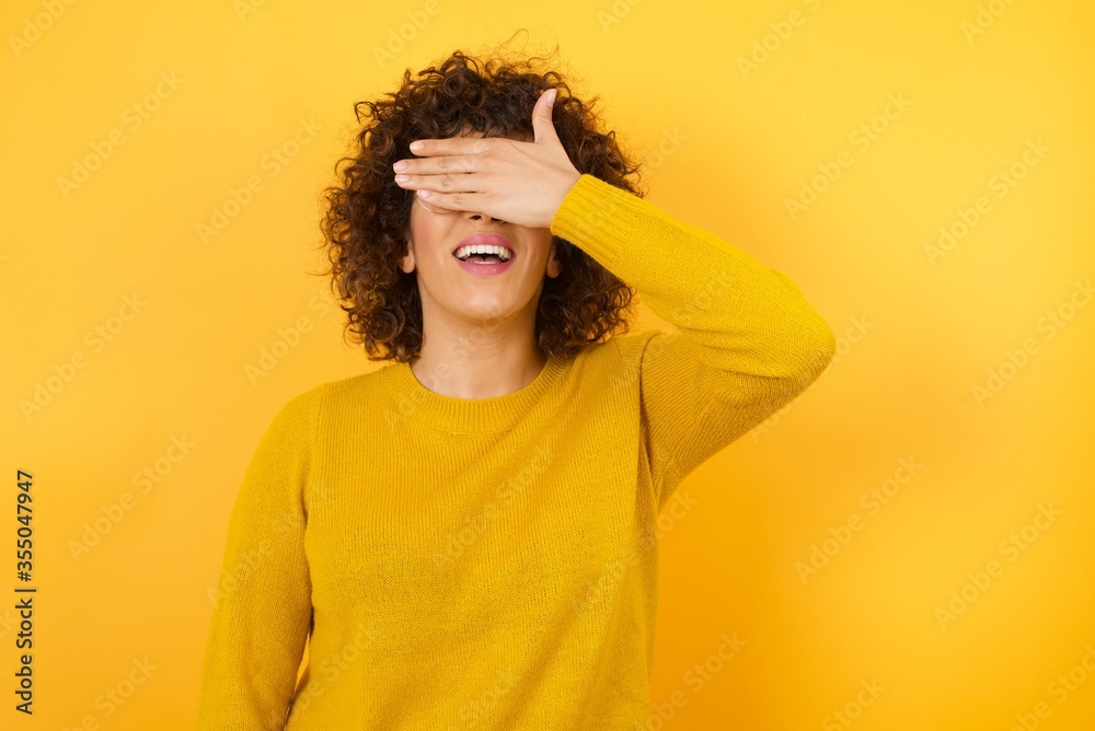 Young Arab woman wearing red casual shirt standing over isolated white background smiling and laughing with hand on face covering eyes for surprise. Blind concept. Young Arab woman wearing red casual shirt standing over isolated white background smiling and laughing with hand on face covering eyes for surprise. Blind concept.