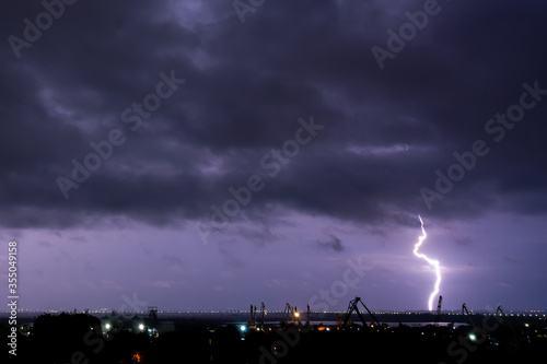 bright lightning in the night sky with a view of the city. spring rain with thunder. bad weather. Lightning strike