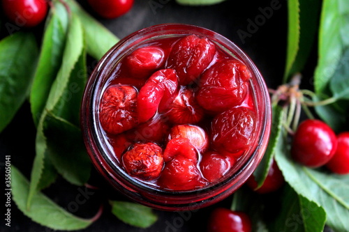 Cherry jam in a glass jar close-up.
