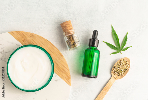 CBD cream infused with cannabis extract for an all natural skin care solution, photography flat lay of cannabis products. Medical use for treatment of topical skin conditions and joint pains. 
