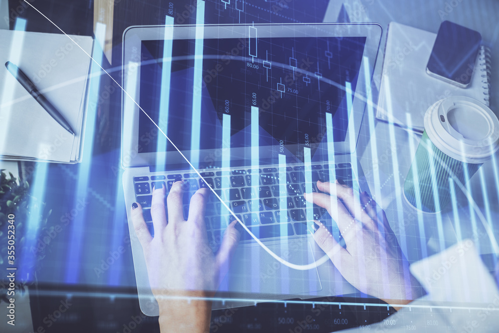 Double exposure of woman hands typing on computer and forex chart hologram drawing. Stock market invest concept.