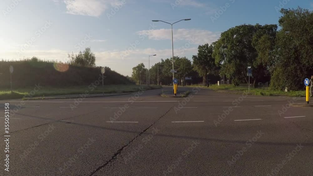 Lockdown shot of vehicles moving at road intersection against sky on sunny day - Breda, Netherlands Lockdown shot of vehicles moving at road intersection against sky on sunny day - Breda, Netherlands