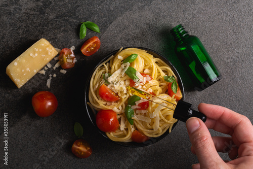 Cannabis CBD spaghetti pasta overhead food photography on black background. Made with CBD infused marijuana oil. Cannabis edibles for medication or recreational enjoyment of weed. Eating your pot.