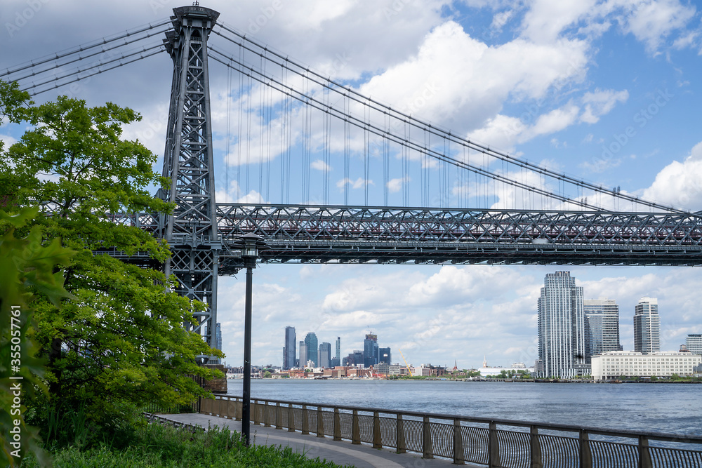 Fototapeta premium An empty promenade along East River in lower Manhattan with a view of Williamsburg Bridge