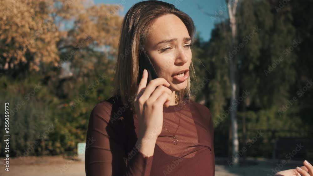 Confident girl emotionally arguing on the phone with her boyfriend outdoor. Beautiful annoyed angry girl ironically talking on the phone Confident girl emotionally arguing on the phone with her boyfriend outdoor. Beautiful annoyed angry girl ironically talking on the phone