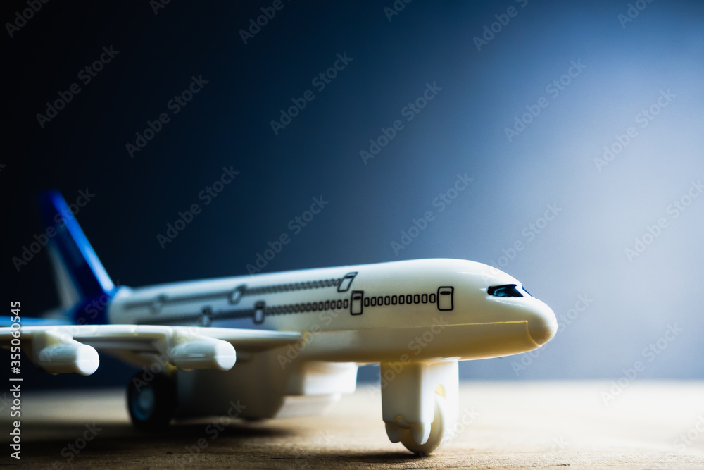 White blue toy plane Placed on a black background Light comes out from