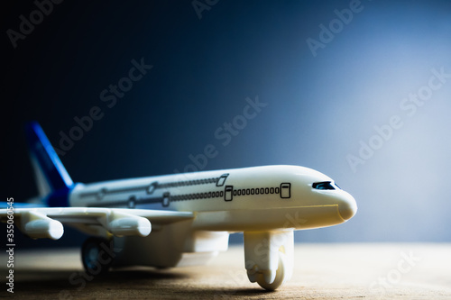 White blue toy plane Placed on a black background Light comes out from the side. Copy space concept. Impact of COVID-19  impact on airlines  air transportation.