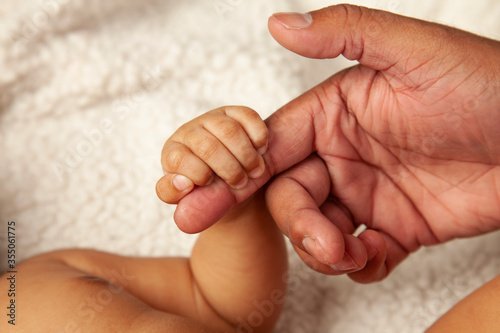 Tiny baby hand gripping onto daddy's finger – Father's day