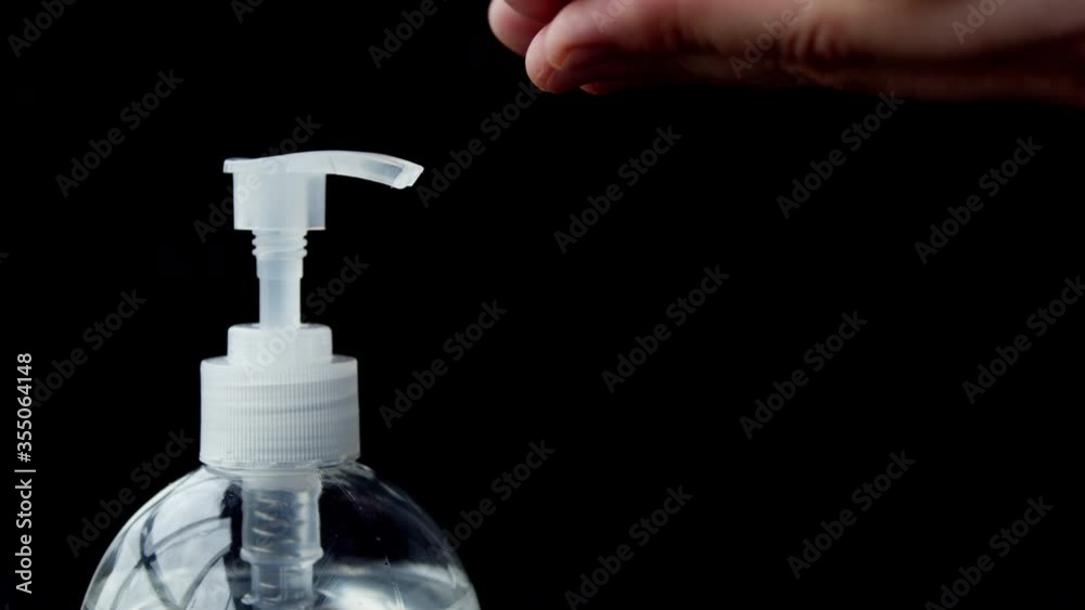 Cleaning hands with hand sanitizer sanitiser gel used for hygiene and keeping hands clean to prevent virus spread. Man washing hands using alcohol based fluid. Front view on black background. Cleaning hands with hand sanitizer sanitiser gel used for hygiene and keeping hands clean to prevent virus spread. Man washing hands using alcohol based fluid. Front view on black background.