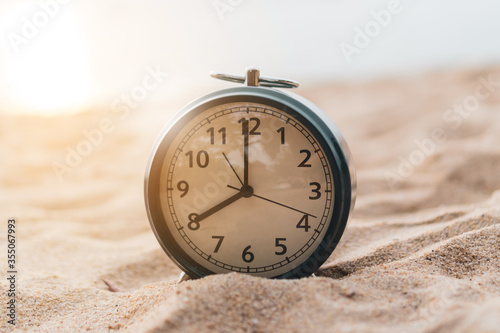 Selective focus of alarm clock with nature background.