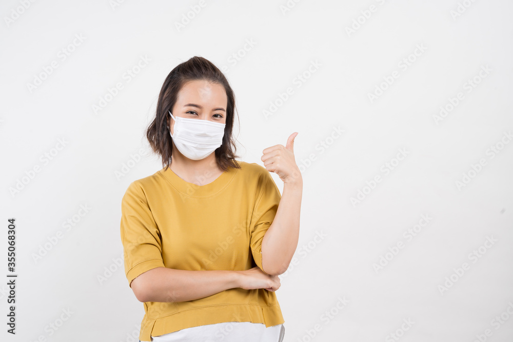 Young Asian woman wearing hygienic mask to prevent infection corona virus Air pollution pm2.5 she wearing a yellow T-shirt shoot in shot isolated on white background Young Asian woman wearing hygienic mask to prevent infection corona virus Air pollution pm2.5 she wearing a yellow T-shirt shoot in shot isolated on white background
