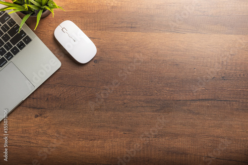 Flat lay of Office desk wooden table with laptop and computer white mouse with copy space, top view
