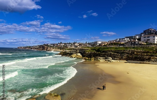 Tamarama Beach in Sydney NSW Australia on a sunny winters day partly cloudy skies Pacific Ocean waves and nice sandy beach