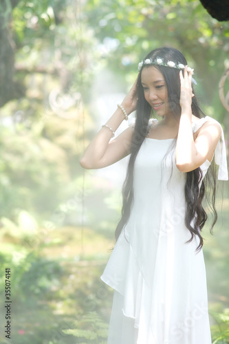 portrait of beautiful young woman with white dress in the forest