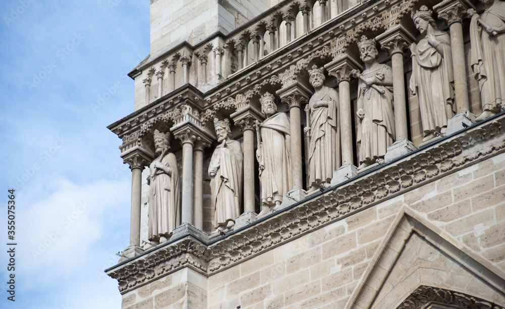 Notre Dame de Paris in a beautiful summer day. Close up on sculptures of row of men on a facade of the cathedral