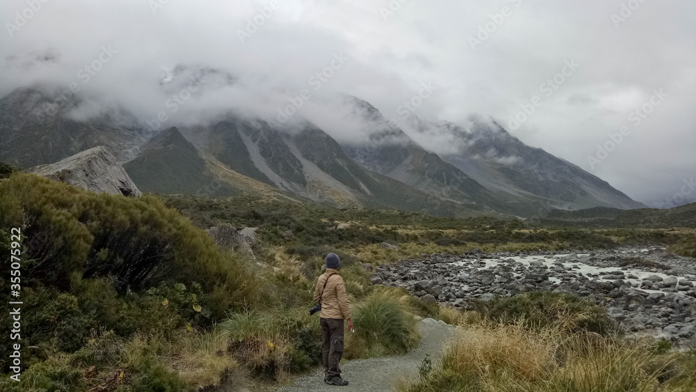 A man walking inside Mount Cook National Park in New Zealand