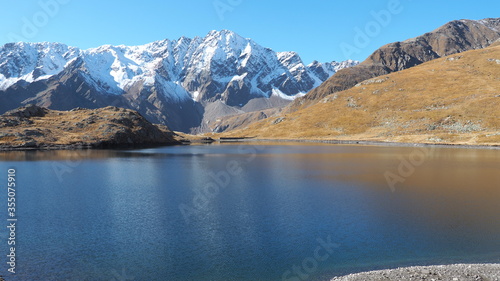 Italian Alps. Italy. Wonderful view of the a natural alpine lake. The Black lake close to Gavia mountain pass. In the background the snowy Alps
