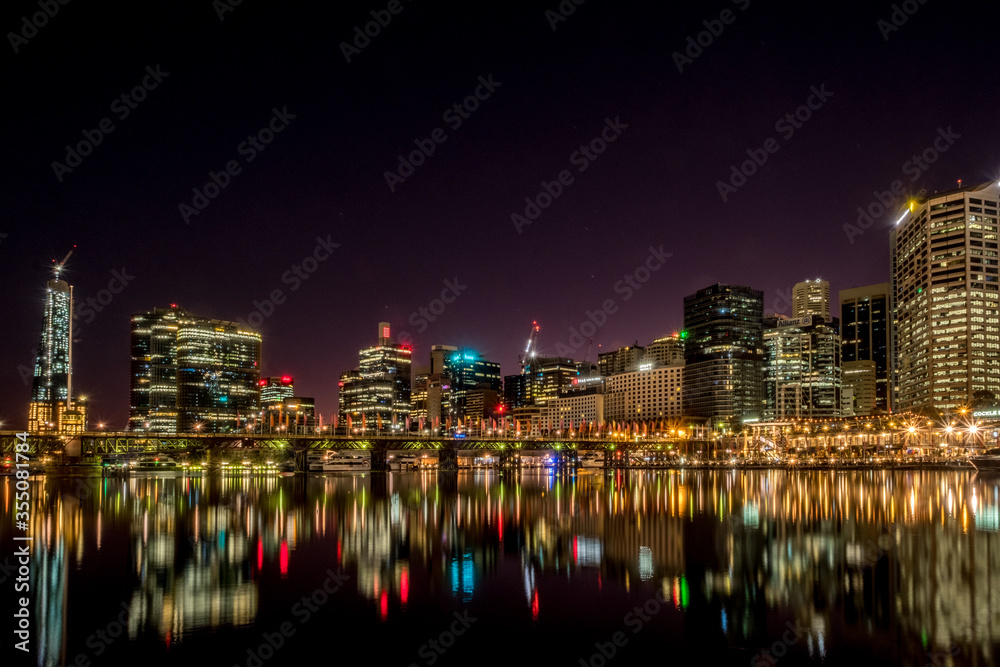 Naklejka premium night time cityscape with water reflections
