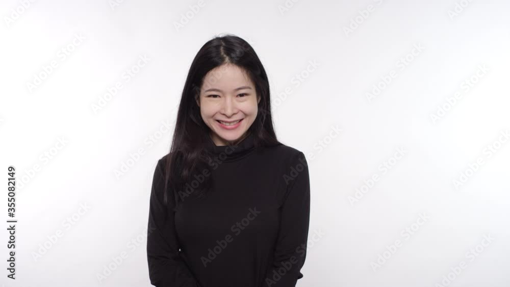 Woman of Asian descent laughing smiling and covering her mouth with her hand Woman of Asian descent laughing smiling and covering her mouth with her hand