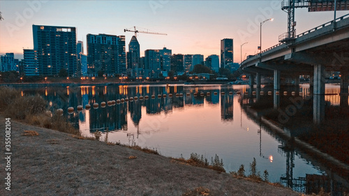 Griffintown's area silhouette in pink sunset with reflections in calm canal and a bridge aside