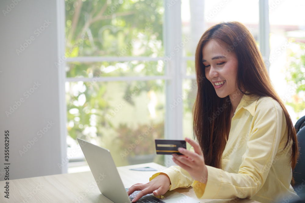 Young Asian woman doing online shopping and using credit card for payment at home Young Asian woman doing online shopping and using credit card for payment at home