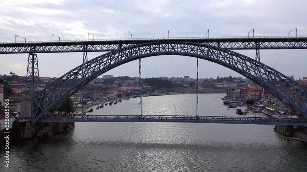 Aerial shot of tourists on famous bridge over river against sky, drone flying backward from landmark in city - Porto, Portugal Aerial shot of tourists on famous bridge over river against sky, drone flying backward from landmark in city - Porto, Portugal