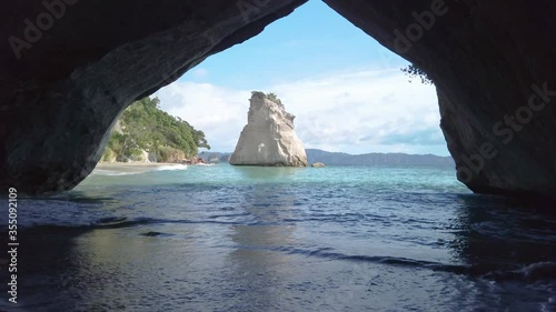 4k hand held stationary motion of the rock formation know as Cathedral Cove on the coromandel Peninsula,tourist destination that became famous from a a movie film location,north island,New Zealand  photo